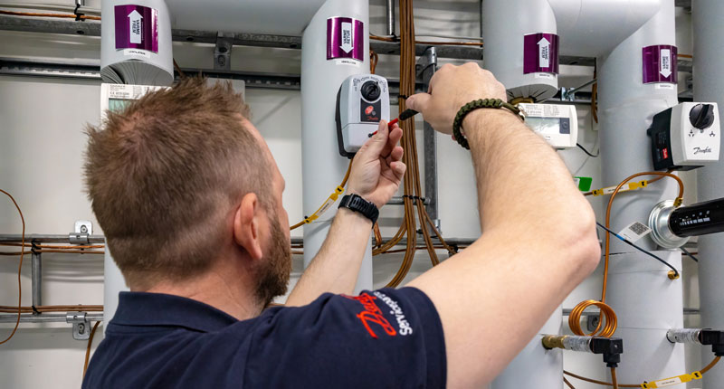 Medarbejder hos STYREG Heating laver service på teknisk anlæg